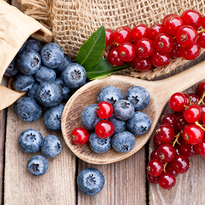 Ein Holzlöffel mit Heidelbeeren und Johannisbeeren