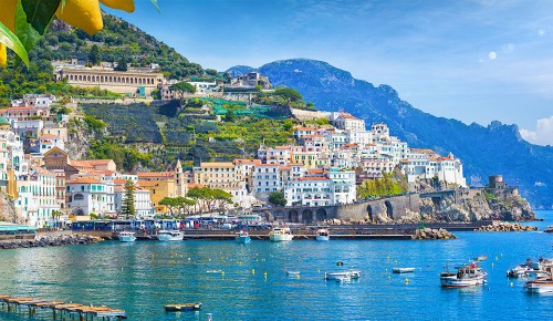 Panoramablick auf das wunderschöne Amalfi auf Hügeln, die zur Küste hinabführen