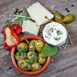 Verschiedene Antipasti wie Käse, Kapern und Oliven auf einem Tisch
