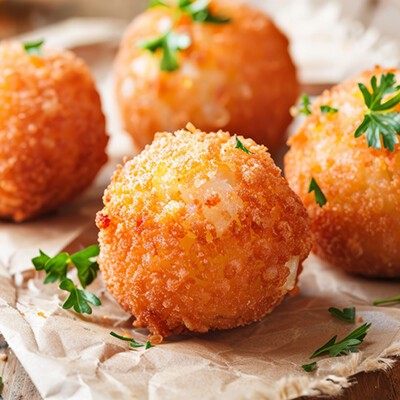 Frittierte Arancini-Bällchen auf rustikalem Hintergrund