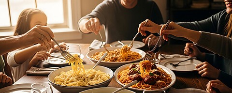 Eine Familie beim gemeinsam Essen von verschiedenen Pastagerichten