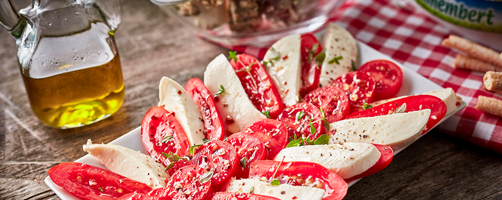 Aufgeschnittene und geschichtete Mozzarella-Scheiben mit Tomaten
