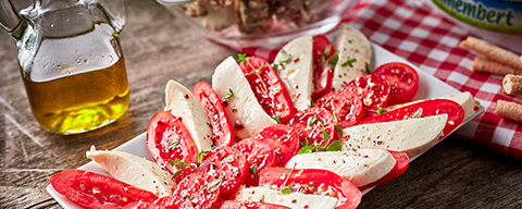 Aufgeschnittene und geschichtete Mozzarella-Scheiben mit Tomaten