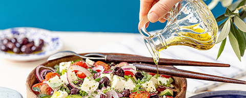 Olivenöl wird in einen griechischen Salat von der SPAR Mahlzeit! gegossen