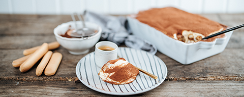 Ein Tiramisu in einer Schale und ein Stück Tiramisu auf einem Teller - Rezeptbild aus der SPAR Mahlzeit