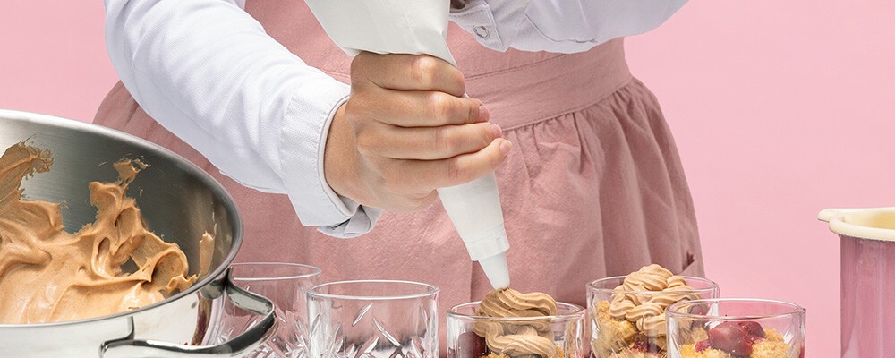 Lisa Krispl füllt eine Teigmasse in ein Glas