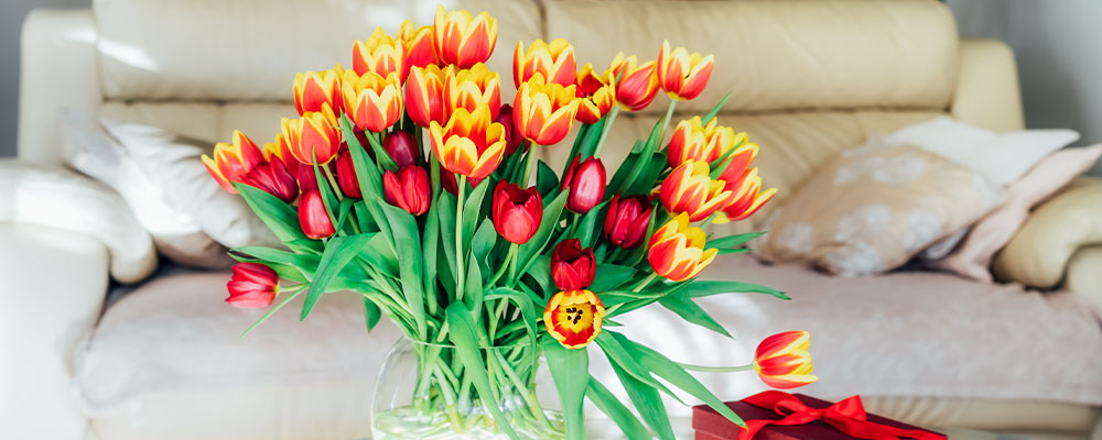 Eine große Vase voller rot-orangener Tulpen