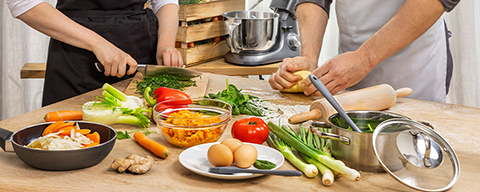Zwei Personen beim gemeinsamen Kochen auf einer Kücheninsel