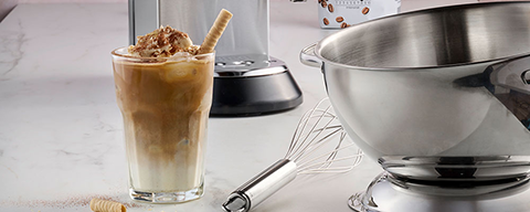 Ein Iced Kaffee Latte neben Backutensilien auf einem Tisch