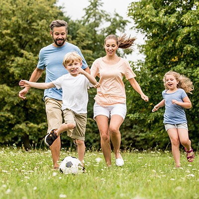 Familie und Kinder spielen Fußball im Garten