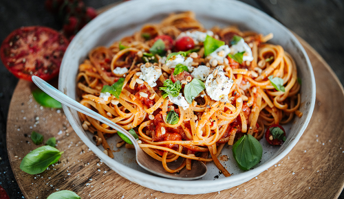 Eine Pasta mit Tomatesauce, frischem Balikum und Pinienkernen - Rezeptbild aus der SPAR Mahlzeit