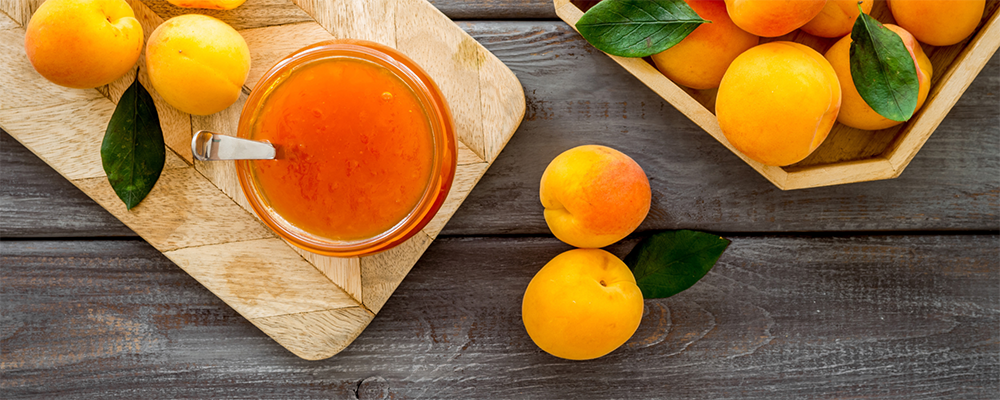 Mehrere reife, gelb-orange Marillen auf einem Holzbrett