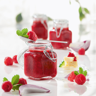 Mehrere Gläser mit roter Marmelade auf einem Tisch