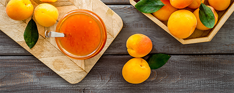 Mehrere reife, gelb-orange Marillen auf einem Holzbrett