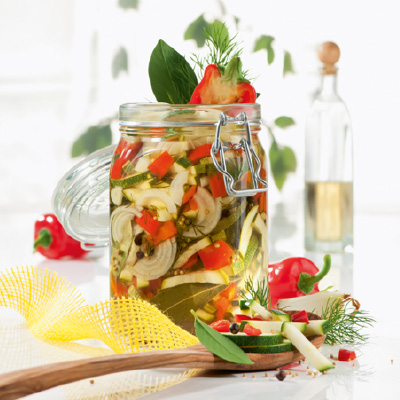 Ein großes Glas voller eingelegter Paprika und Zucchini