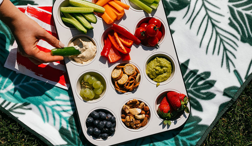 Ein Blech mit Muffinformen, gefüllt mit Obst, Snacks, Beeren und mehr 