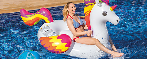 Eine Frau auf einem aufblasbaren Einhorn in einem Pool