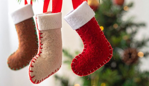 Selbst gebastelter Christbaumschmuck aus Filz in Form von kleinen Sockenhängt am Christbaum