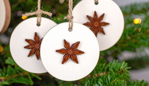 Selbst gebastelter Weihnachtsschmuck aus Salzteig und Gewürzen hängt an einem Christbaum
