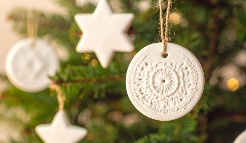 Selbst gebastelter Weihnachtsschmuck aus Salzteig hängt an einem Christbaum