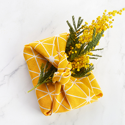 Ein, in ein gelbes Tuch verpackates, Geschenk