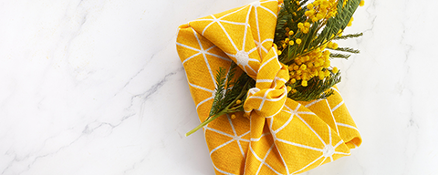 Ein, in ein gelbes Tuch verpackates, Geschenk