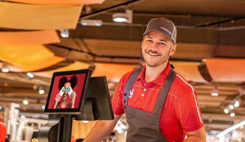 Ein Mitarbeiter in einem INTERSPAR Frischebereich lächelt in die Kamera