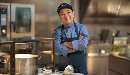 Ein Mitarbeiter in der INTERSPAR Gastronomie lächelt in die Kamera