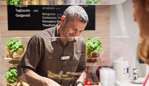 Ein Restaurant-Mitarbeiter beim Austeilen von Essen