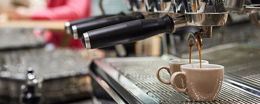 Frischer Kaffee der in eine Tasse rinnt