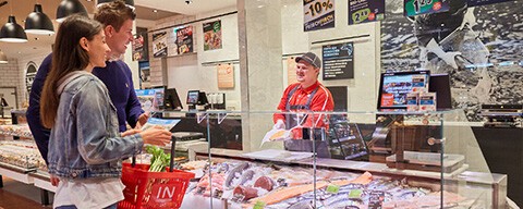 Zwei Personen beim Einkaufen an einer INTERSPAR-Fischtheke