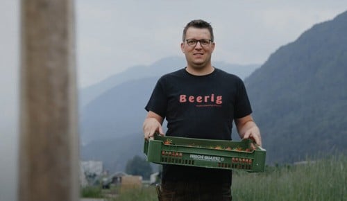 Ein Mann mit einer Palette Beeren in den Händen