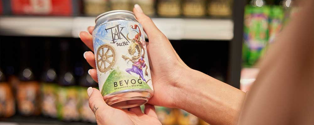 Detailaufnahme einer Craft Beer-Flasche in den Händen einer Person
