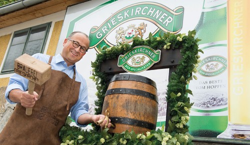 Ein Mitarbeiter vom Grieskirchner Bier neben einem Fass Bier