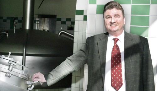 Ein Mitarbeiter vom Hubertus Bräu neben einem Bierkessel