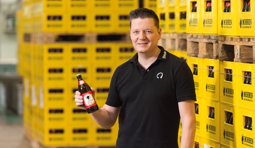 Ein Mitarbeiter der Mohrenbrauerei mit einer Bierflasche im Lager