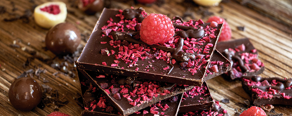 Delikatessen aus Österreich Mehrere, mit Himbeeren garnierte, Tafeln Schokolade