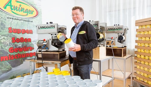 Ein Mitarbeiter von Auingers Suppen neben einem Förderband