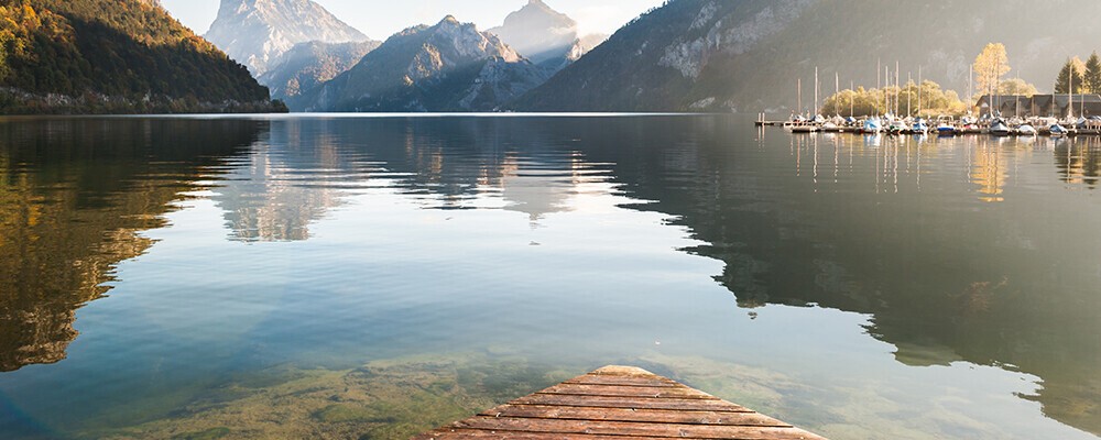 Ein spiegelnder Bergsee in der Abenddämmerung vor einem Gebirge