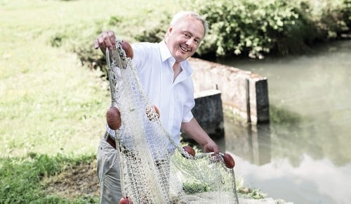 Ein Mitarbeiter von Kulmer Fisch mit einem Netz in den Händen