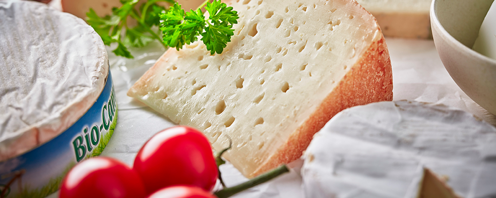 Ein Stück Rotschmierkäse und ein Weichkäse auf einem Teller
