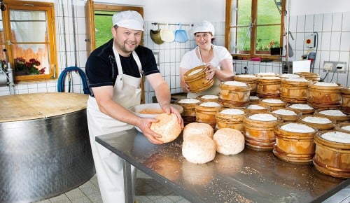 Ein Mitarbeiter der Alpe Nova beim einreiben von Käse