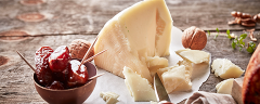 Ein mürber Hartkäse neben einem Käsemesser