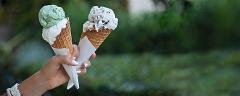 EIne Hand die zwei Eiswaffeln mit Eiskugeln in den Händen hält