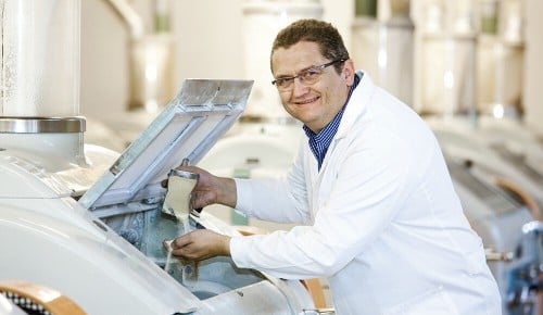 Ein Mitarbeiter der Vorarlberger Mühlen neben einer Mühle