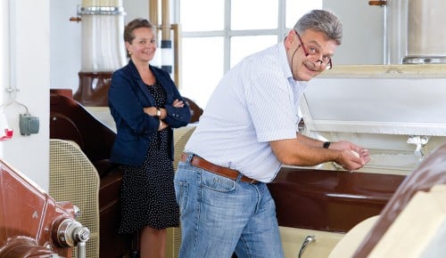 Ein Mann und eine Frau der Walzmühle Assmann neben einer Mühle