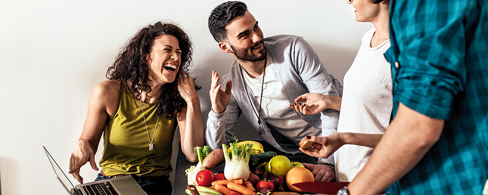 Mehrere Personen beim gemeinsamen Kochen von Gemüse