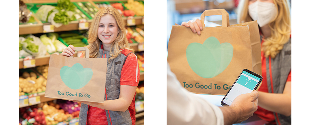Eine INTERSPAR-Mitarbeiterin mit einem Too Good To Go Sackerl in den Händen