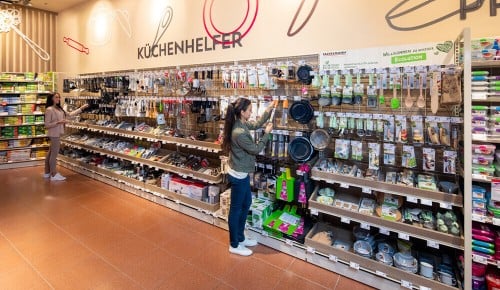 Eine Kundin an einem Regal in der Abteilung "Küche und Tisch" bei INTERSPAR