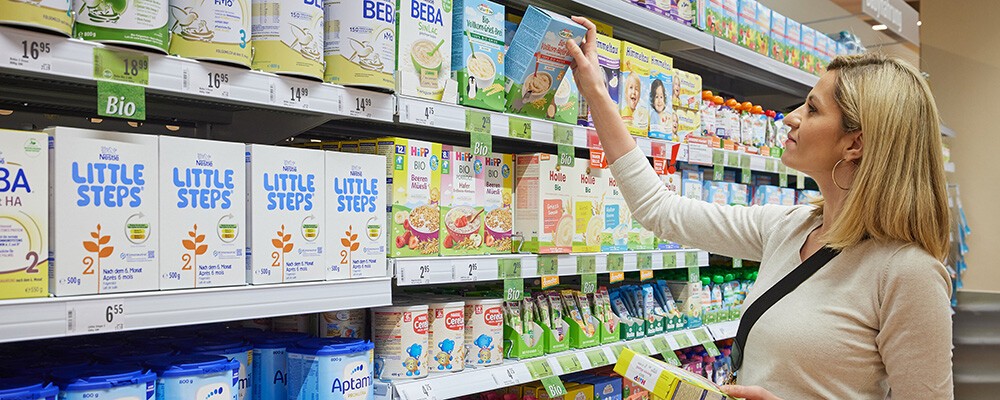 Eine Frau in einem INTERSPAR-Hypermarkt beim Einkaufen von Babyanfangsnahrung